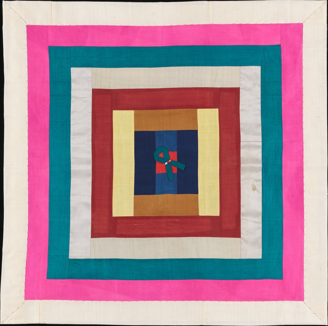 A square Korean patchwork wrapping cloth with concentric bands of pink, teal, white, red and yellow around a navy centre.