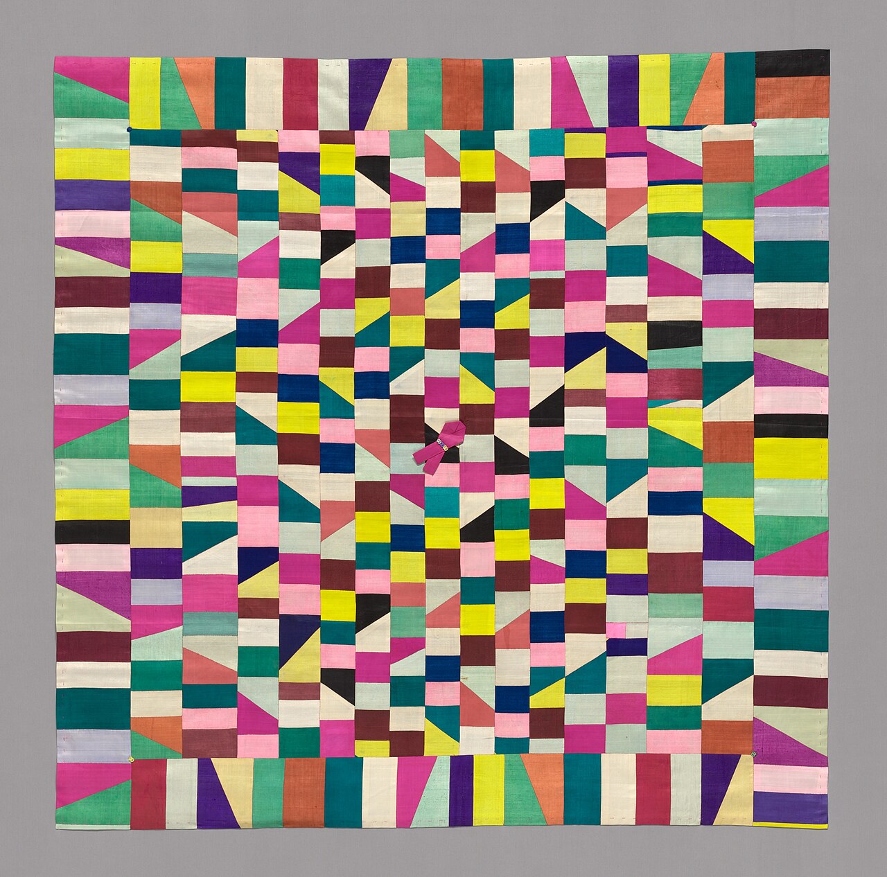 A square Korean silk wrapping cloth pieced from many small multicoloured rectangles and triangles.